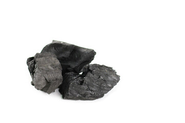 Obraz premium Isolated pieces of black charcoal resting on a clean white background, showcasing its rough texture and deep, rich color. 