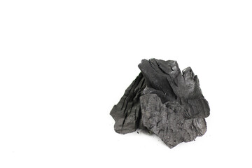 Isolated pieces of black charcoal resting on a clean white background, showcasing its rough texture and deep, rich color. 