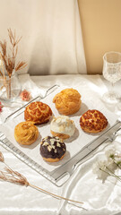 A selection of unique pastries displayed on a tray with delicate floral decor and elegant drinkware, creating a warm atmosphere