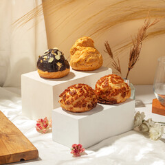 Cream puffs featuring chocolate, almond, and caramel toppings are beautifully arranged in a dessert display