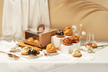 A collection of various filled pastries with creamy toppings is elegantly arranged on a table,...