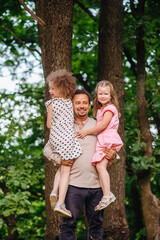Fototapeta premium A father hugging his daughters, showing love and affection. Ideal for themes related to family, bonding, love, and childhood