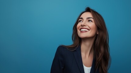 Fototapeta premium A businesswoman laughs against a blue background