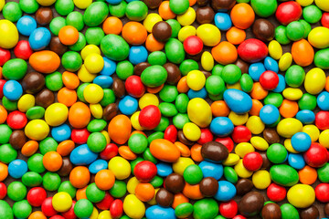 Top view of colourful sweets on the table background. Pile of vibrant colorful candies.