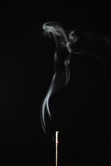 Smoke from incense stick on black background