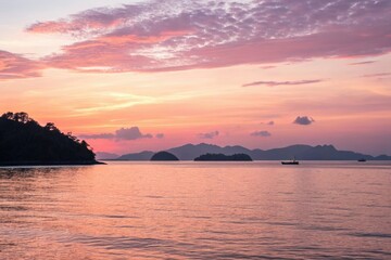 Soft pinks and blushing peaches illuminate a tranquil ocean scene as the sun sets behind a row of islands in the distance, natural beauty, landscape, pink, sunset, beach