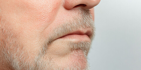 Obraz premium Close-up of Male Face Showing Skin Texture, Lips, and Grey Beard