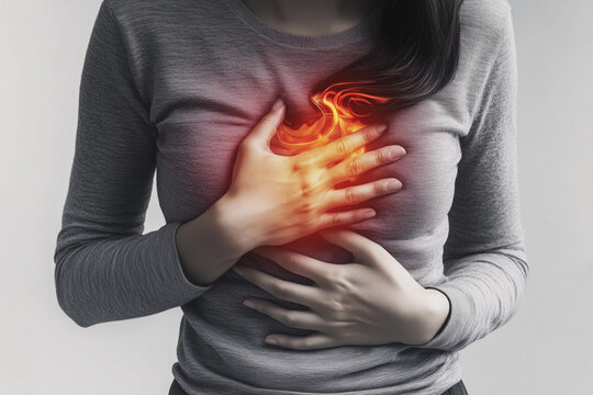 Close-up of a woman with their hand over their chest in pain from heartburn. Gastroesophageal Reflux Disease.
