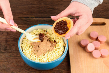 Adding sauce and soup dressing to instant noodles.