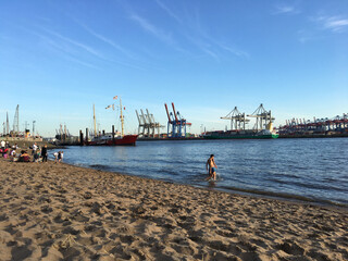 People Swimming at Hamburg’s Elbstrand with the Harbor in the Background