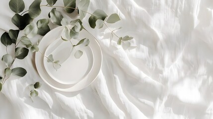 Elegant White Table Setting with Fresh Greenery and Textured Fabric