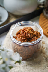 A bottle of dark colored cookies.  Coffee Cookies.  Biskut Kopi.