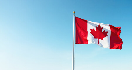 Banner flag of Canada against a background of blue clear sky on the right side, concept National Flag of Canada Day