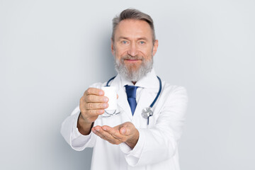 Smiling doctor holding a medication bottle, offering medical care and treatment against a clean white background