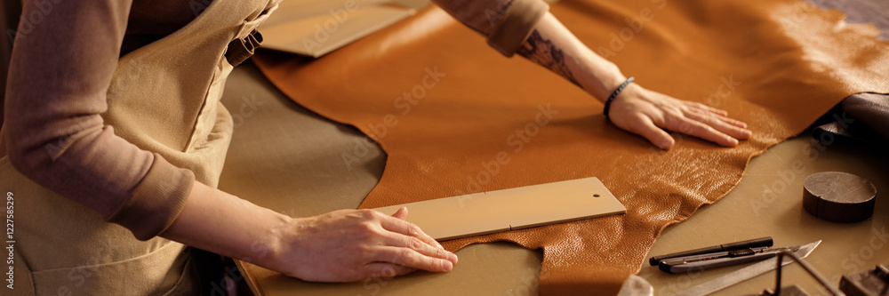 Poster skilled artisan crafting and shaping leather on workbench using various tools performing intricate l