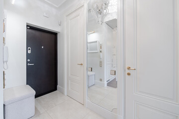 Home Entrance Hall. Interior. Wooden Black Door, Brown Flooring. Minimalism. LED Light. Closed Doors to Living Room. White Bench
