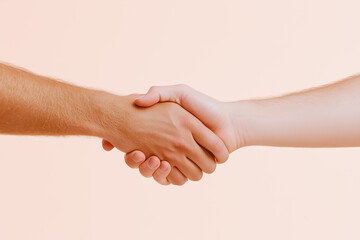 A human hand shakes a robotic arm against a neutral backdrop in even midday light, symbolizing future cooperation and collaboration between humanity and technology