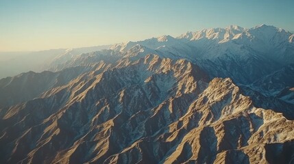 Fototapeta premium Majestic Aerial View of Snow-Capped Mountain Range at Sunrise