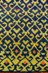 Traditional Turkish carpet ornament with colorful geometric and floral patterns in yellow, blue, and orange tones, woven textile art