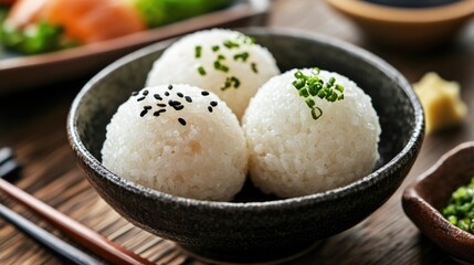 Japanese rice balls garnished with sesame and chives served in a dark bowl showcasing traditional Asian cuisine and healthy meal concepts
