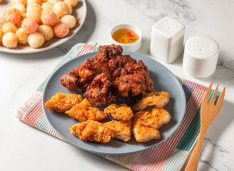 Fried Chicken thigh steak, shrimp steak and potato balls served in plate with fork isolated on napkin side view of taiwan food