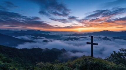 Obraz premium Majestic Wooden Cross Silhouetted Against Vibrant Sunrise Over Misty Mountain Landscape