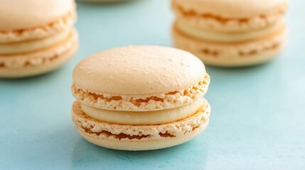 Fototapeta premium Delicious Golden Macarons Stacked on a Soft Light Blue Background Perfect for Baking or Dessert Themes