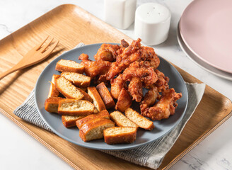Fried chicken legs and dried tofu served in plate with fork isolated on napkin side view of taiwan food