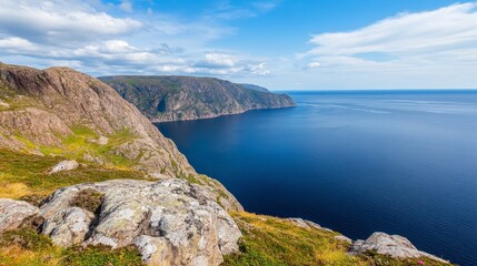 Fototapeta premium Scenic coastal view of rugged cliffs overlooking a tranquil ocean under a bright blue sky