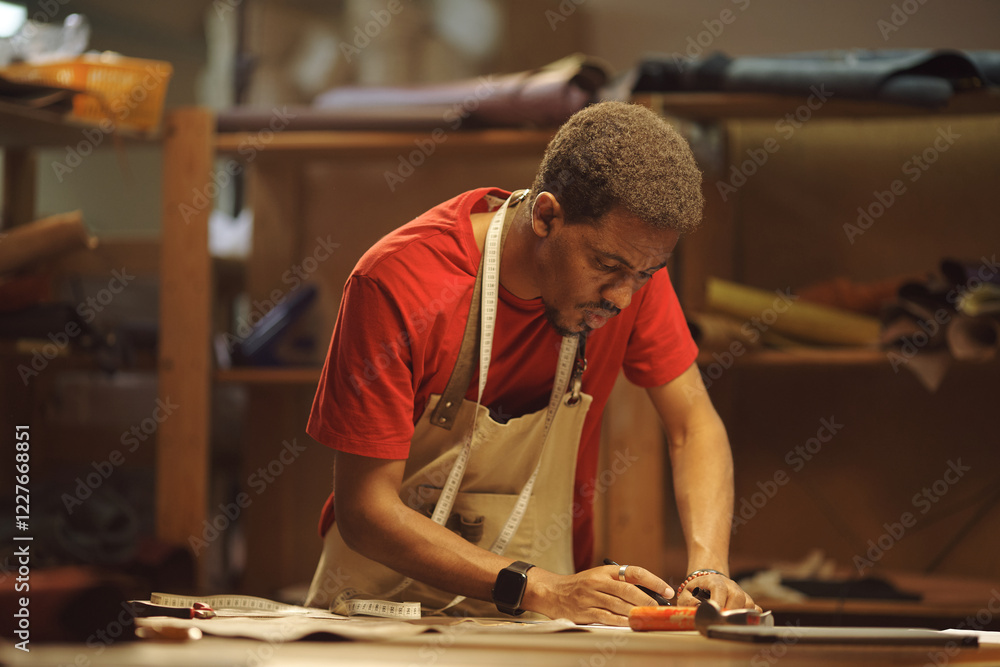 Poster senior african american man focusing on his craft while working with tools in a workshop, showing de