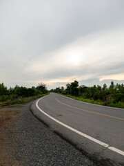 Curved Asphalt Road Along an Irrigation Canal in a Rural Landscape.
