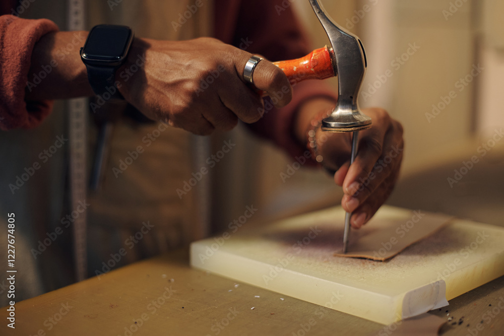 Poster close-up of craftsperson using specialized tool for cutting leather, highlighting precision and skil
