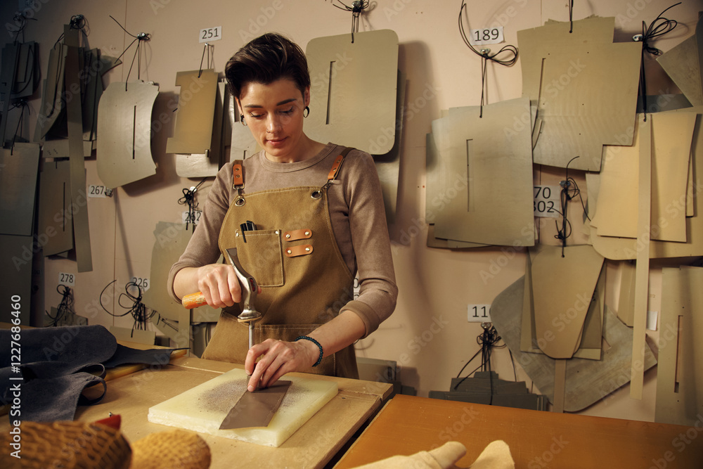 Poster woman concentrating on creating fashion patterns in atelier setting surrounded by various templates 