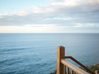 Obraz premium Serene ocean view with a wooden railing in the foreground, leading the eye out to sea, seaside, boat ramp, coastal