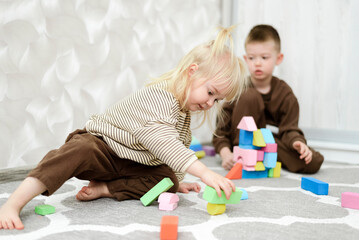 Obraz premium Cute children playing with cubes and blocks