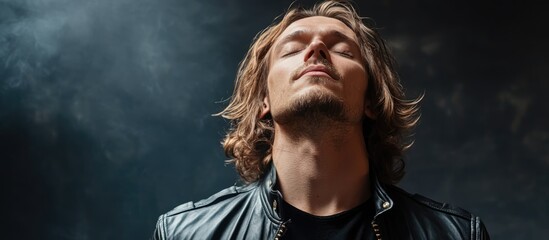 Caucasian man in leather jacket enjoying music with eyes closed in indoor gym setting embodying relaxation and happiness