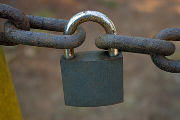 Security lock linking two rusted heavy chains together