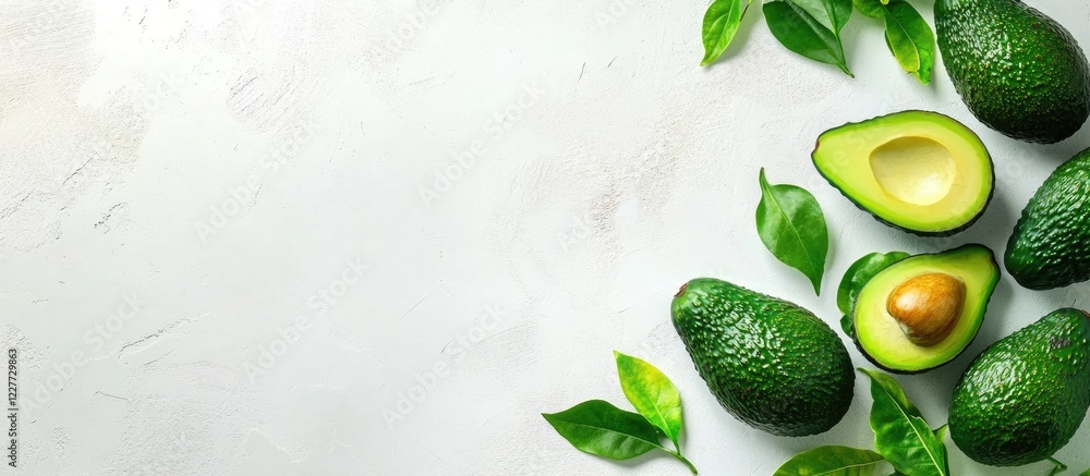 Poster freshly sliced and whole avocados arranged on a light background with empty space for your creative 