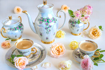Fototapeta premium Festive coffee break; beautiful cups of coffee, coffee pot, rose flowers on white background