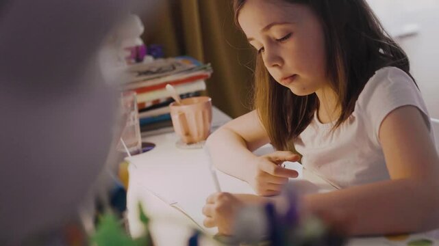 Child doing her homework at the dest at home. Education concept.