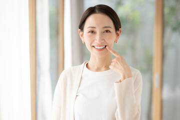 白い歯を指差す女性