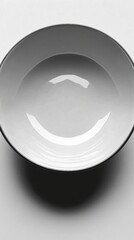 A simple, empty bowl on a plain surface, emphasizing minimalism.