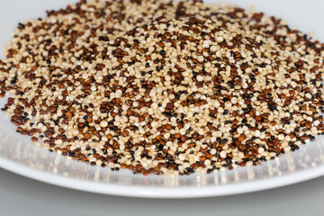Raw black, red and white quinoa seeds mix, close-up