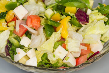 Salad of mozzarella, different vegetables and leaf lettuce, close-up