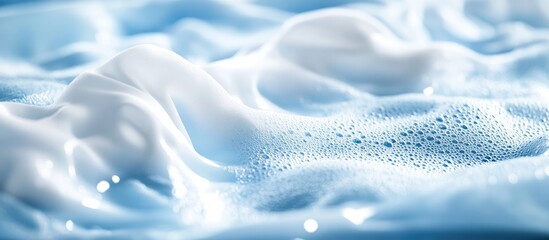 Foaming liquid detergent washing white clothes in machine with soft blue bubbles and empty space for advertising or text placement