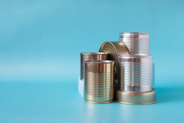 Cans filled with various products in close-up on a colored background of kopi space. Products for long-term storage.