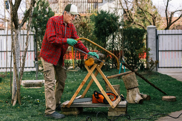 Man cutting wood with hand saw, dust and movements. Chainsaw.