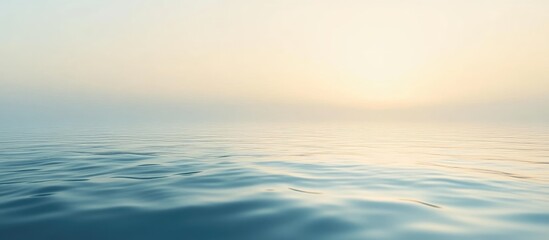 Obraz premium Foggy lake surface at dawn with tranquil water reflections and ample space for text or graphics.