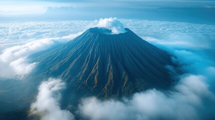 Majestic Volcano Peak Surrounded by Clouds with a Blue Sky and Mountain View