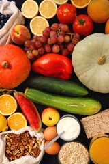 Various healthy fruits, vegetables and cereals on dark background. Top view.